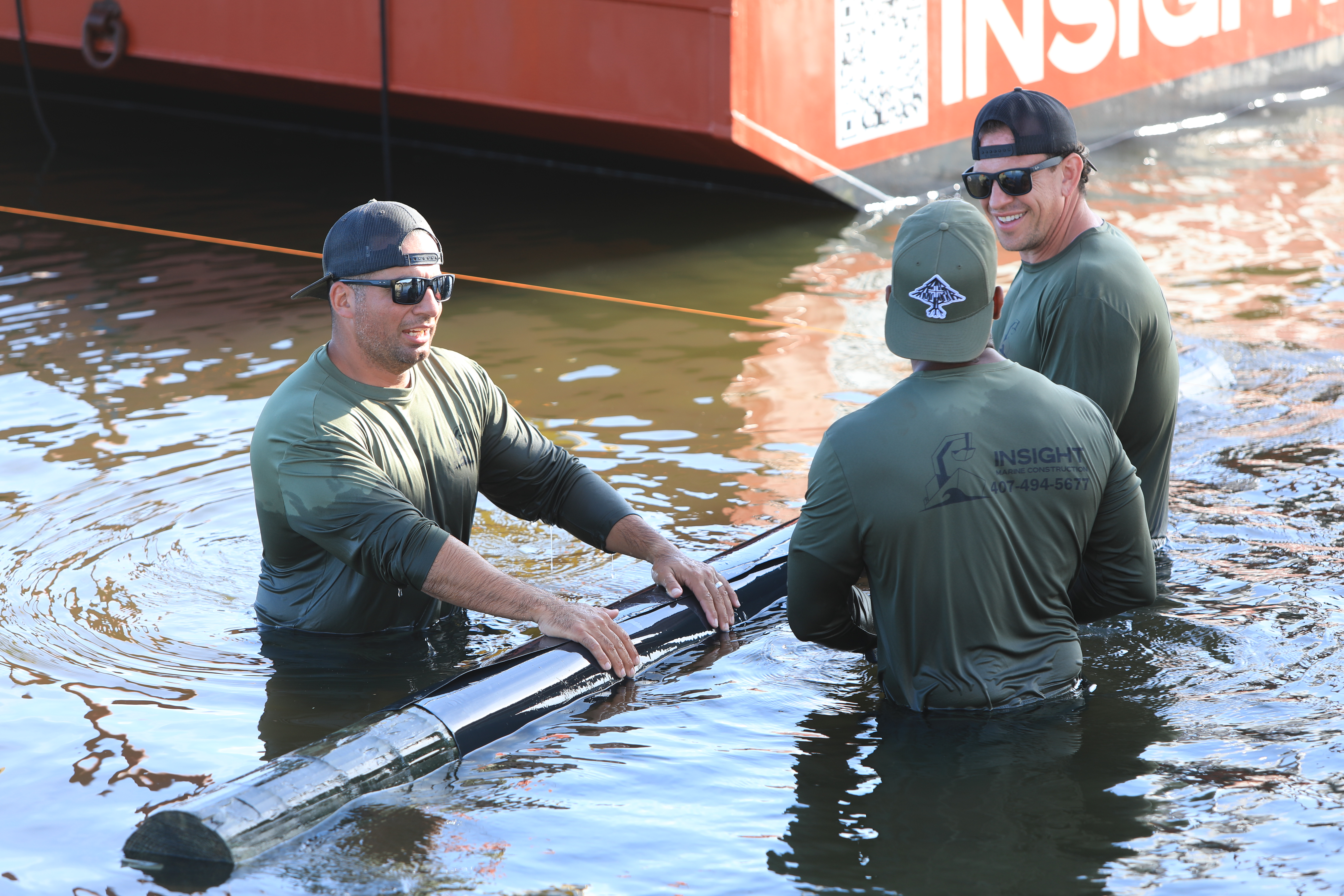 Crew in the water fitting a pile sleeve